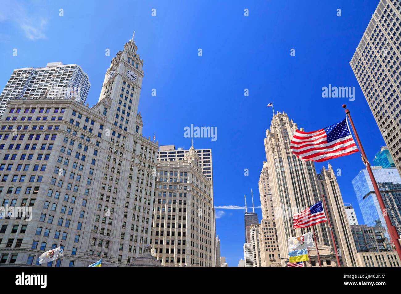 Wrigley Building und Tribune Tower auf der Michigan Avenue mit Illinois Flagge auf den Vordergrund in Chicago, USA Stockfoto