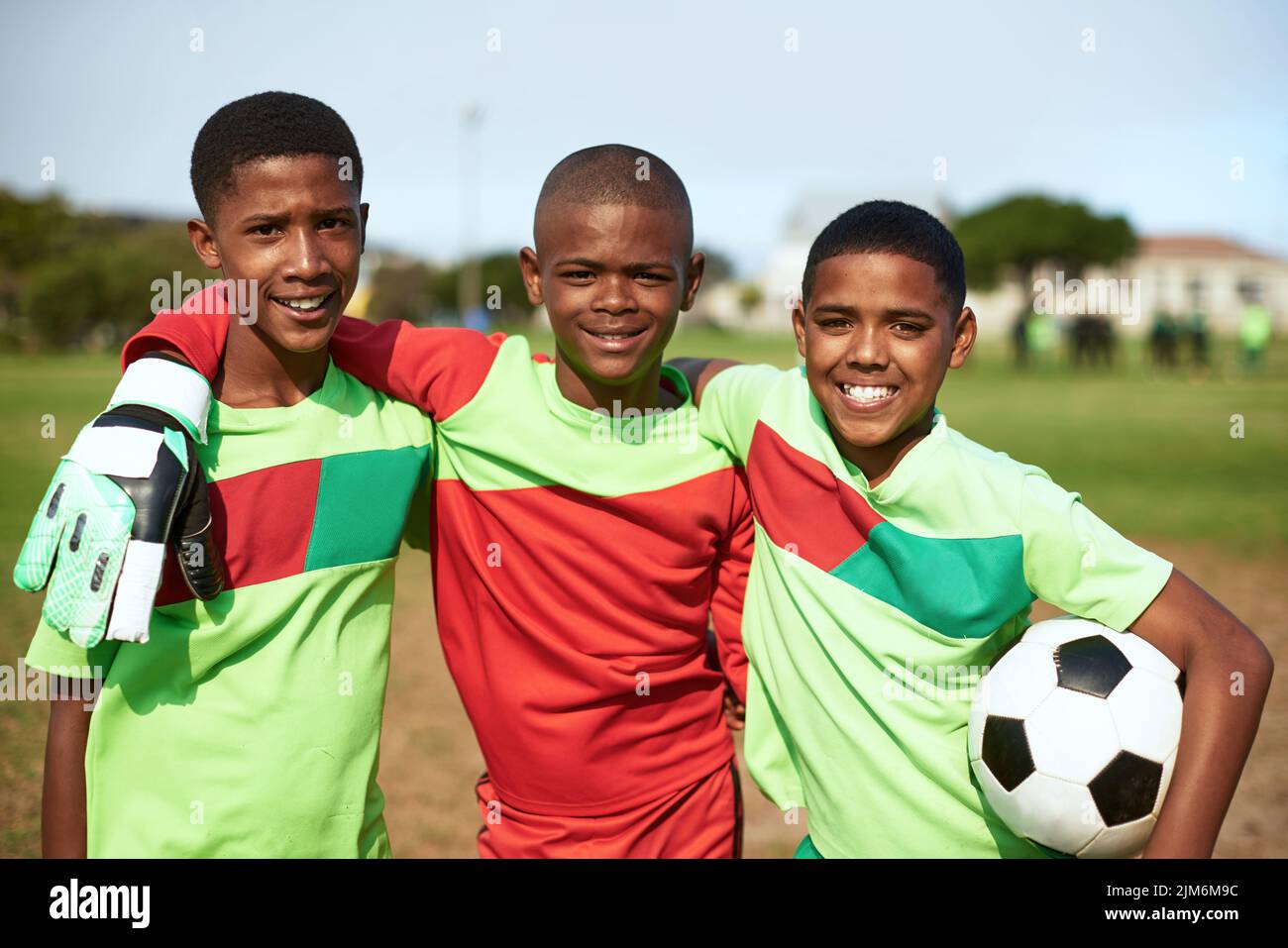Gib uns einfach einen Ball und sei glücklich. Porträt einer Gruppe junger Jungen, die auf einem Sportplatz Fußball spielen. Stockfoto