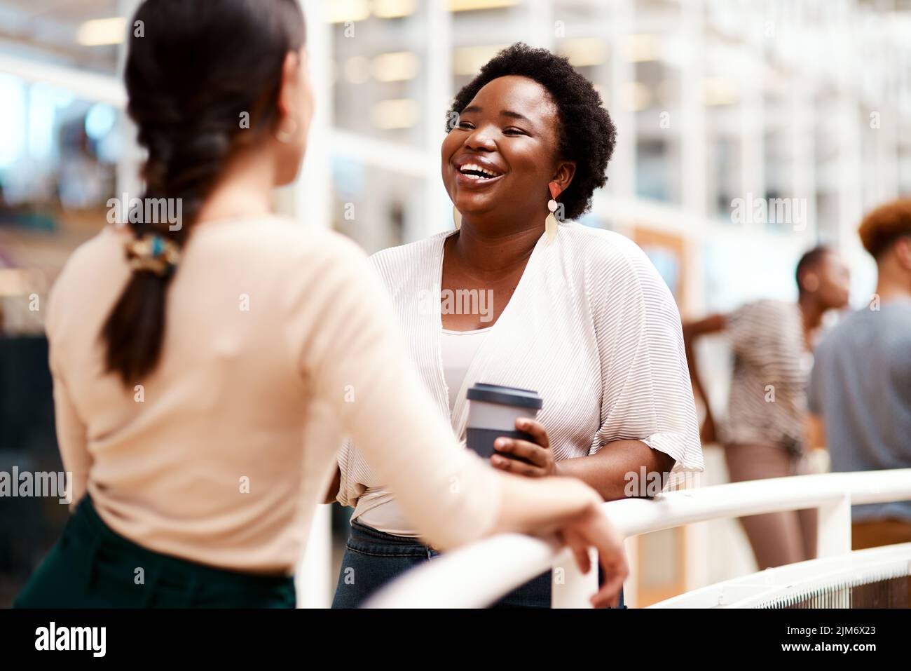 Networking wird helfen, Ihre sozialen Fähigkeiten zu verbessern. Eine junge Geschäftsfrau, die ein Gespräch mit einem Kollegen in einem Büro. Stockfoto