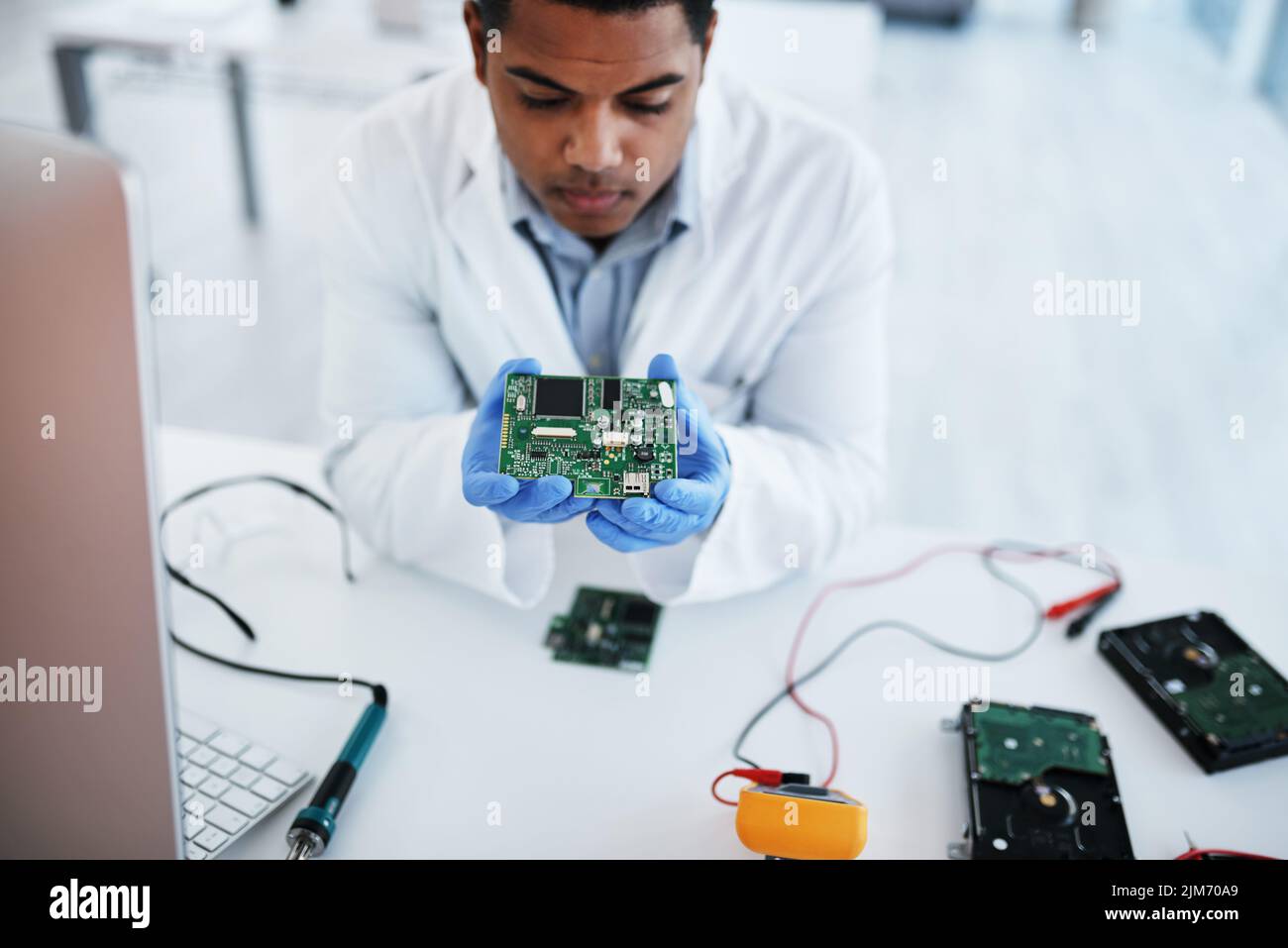 Sie nennen ihn nicht umsonst den Profi. Ein junger Mann, der Computerhardware in einem Labor repariert. Stockfoto