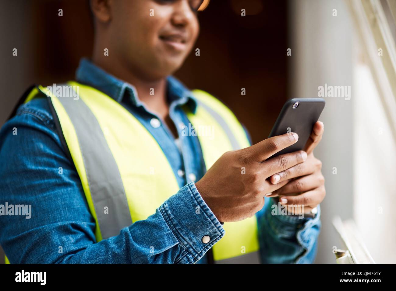 Wenn ich es nicht tun kann, wird jemand in meinen Kontakten. Ein Ingenieur, der sein Handy benutzt, während er auf der Arbeit ist. Stockfoto