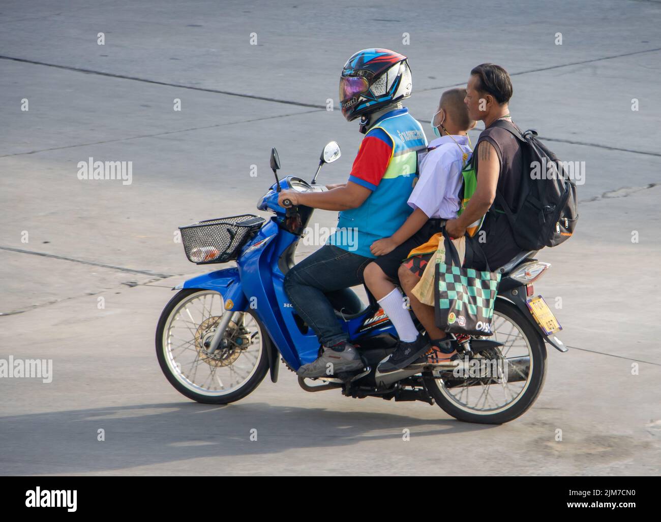 SAMUT PRAKAN, THAILAND, MAI 30 2022, Ein Moto-Taxi trägt einen Mann und einen Jungen in einer Schuluniform Stockfoto