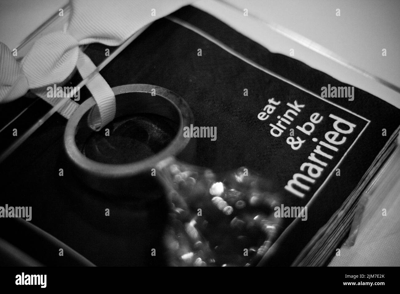 Eine Nahaufnahme von schwarzen Servietten in Graustufen mit Text zum Thema Hochzeit in klarem Acryl-Serviettenhalter Stockfoto