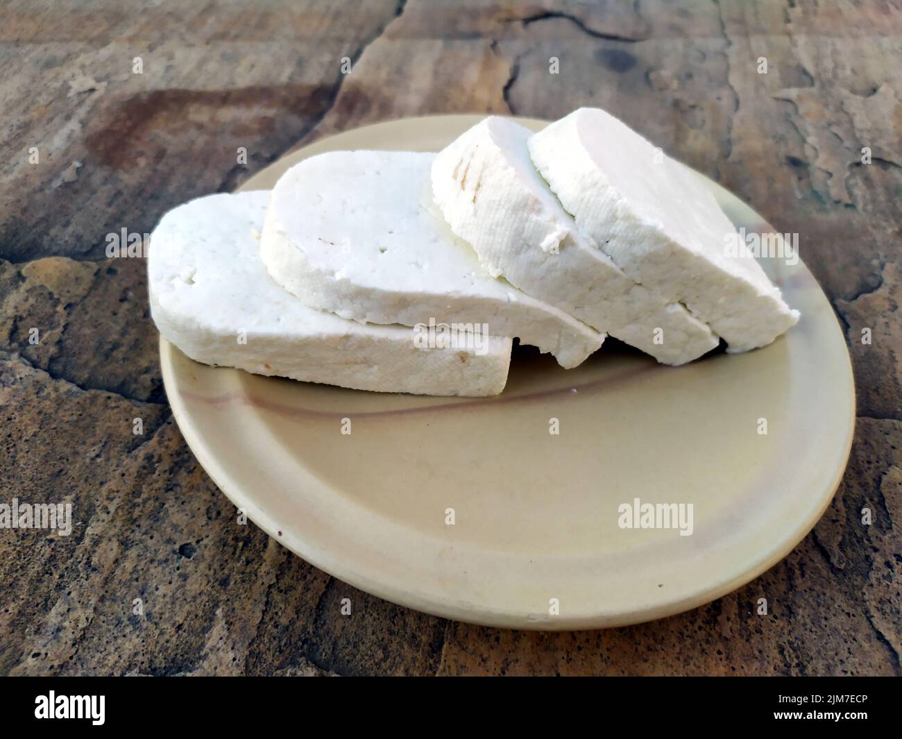 Paneer Scheibe in eine Platte mit Steinhintergrund gelegt Stockfoto