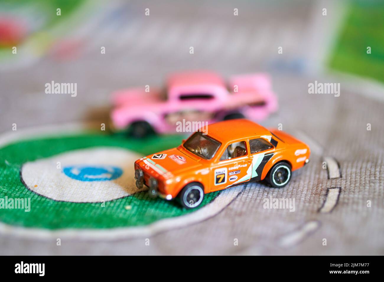 Ein selektiver Fokus auf eine Mischung aus Mattel Hot Wheels Spielzeugmodellen auf einer Spielmatte Stockfoto