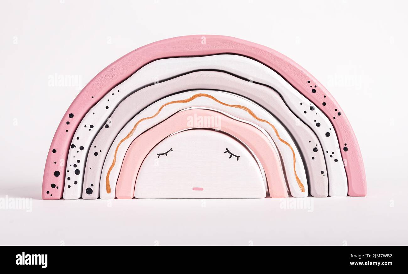 Holz Regenbogen Stapelspielzeug aus Bögen. Schlafkonzept für Kinder. Hübsches Spiel für Kleinkinder in zarten rosa Pastellfarben. Entwicklung der Hand-Auge-Koordination Stockfoto