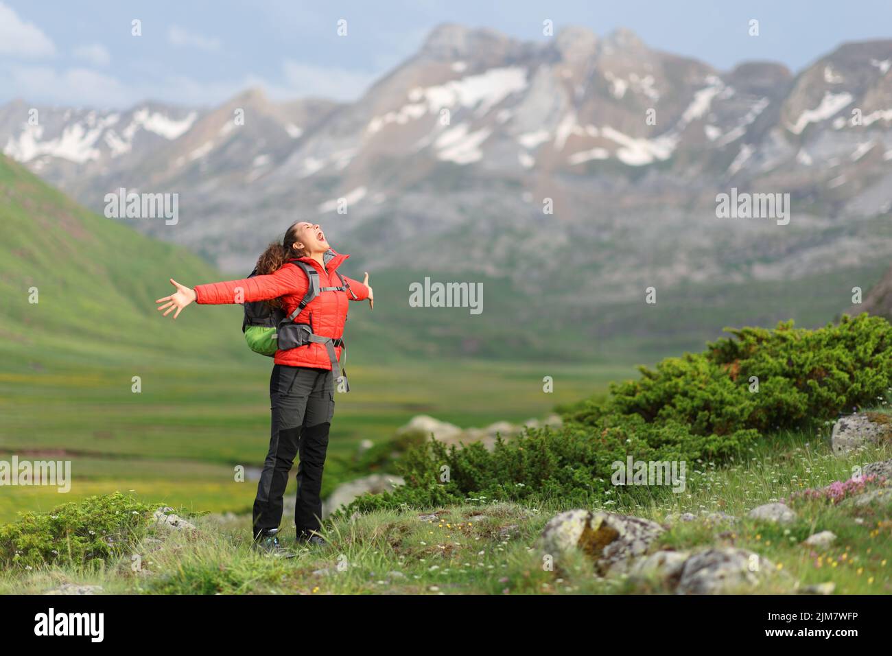 Begeisterter Wanderer, der seinen Urlaub in einem hohen Berg feiert und die Arme ausstreckt und schreit Stockfoto