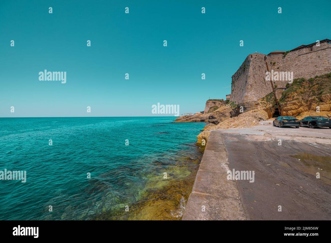 Äußerer Rand der Burg ulcinj, eine Festung am Rande des Wassers im westlichen Teil der Stadt. Parkplatz im Vordergrund. Stockfoto