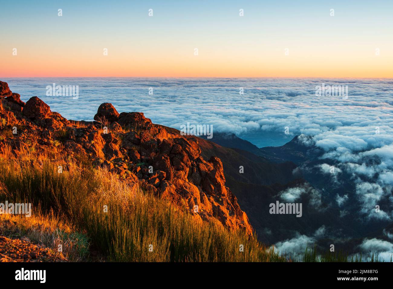 Berglandschaft über Wolken bei Sonnenaufgang Stockfoto