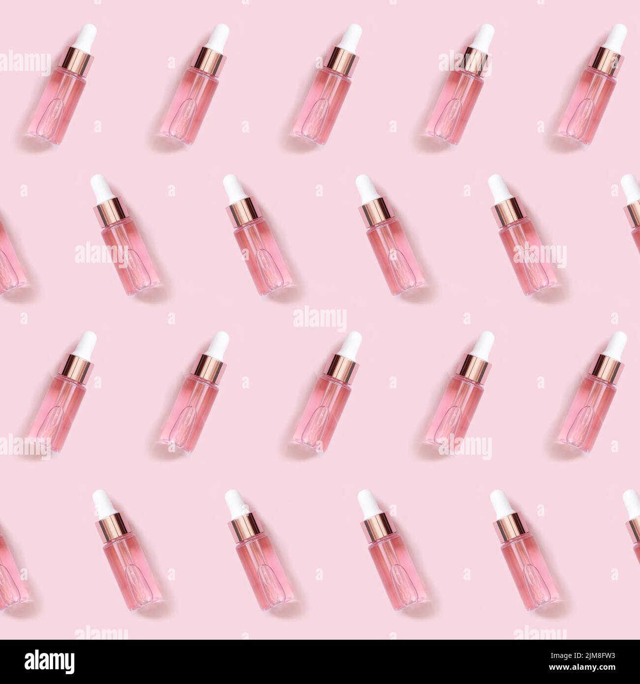 Hellrosa Tropfflasche nahe weißer Orchideenblume auf hellrosa, Muster, Draufsicht, Mockup. Hautpflegeprodukte, aromatisches Öl oder Serum. In Pastelltönen gehalten Stockfoto