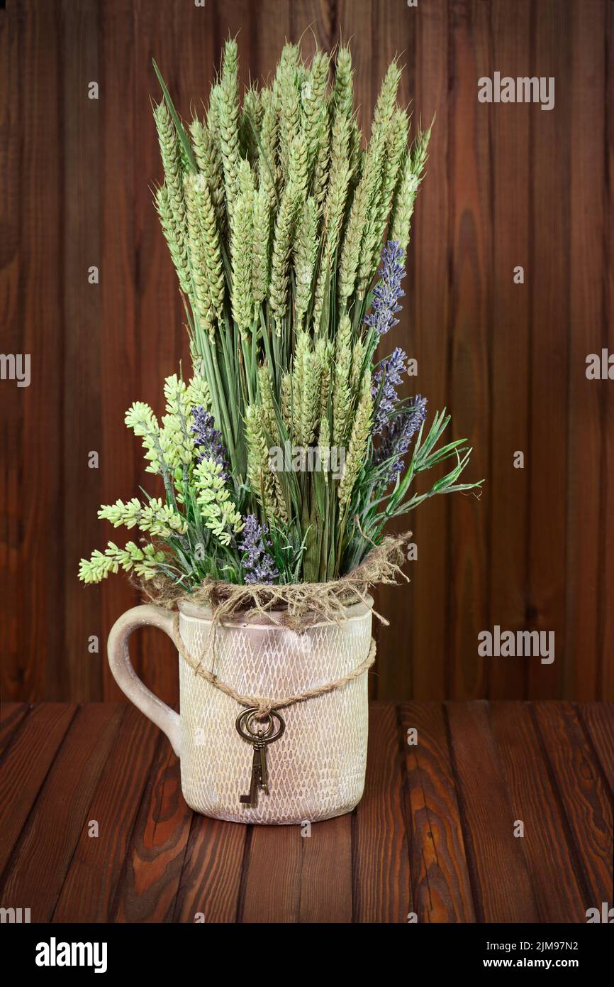 Stillleben von Blumen und Roggenohren in Vintage Vase mit Schlüsseln. Stockfoto