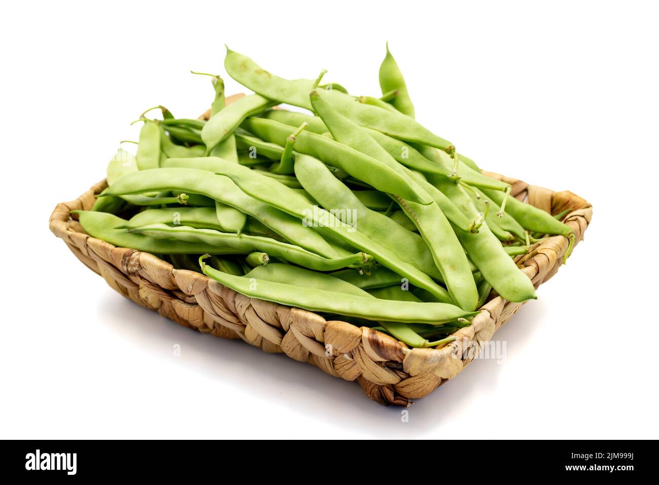 Reife grüne Bohnen. Frische und rohe grüne Bohnen im Korb isoliert auf weißem Hintergrund. Bio-Lebensmittel. Nahaufnahme Stockfoto