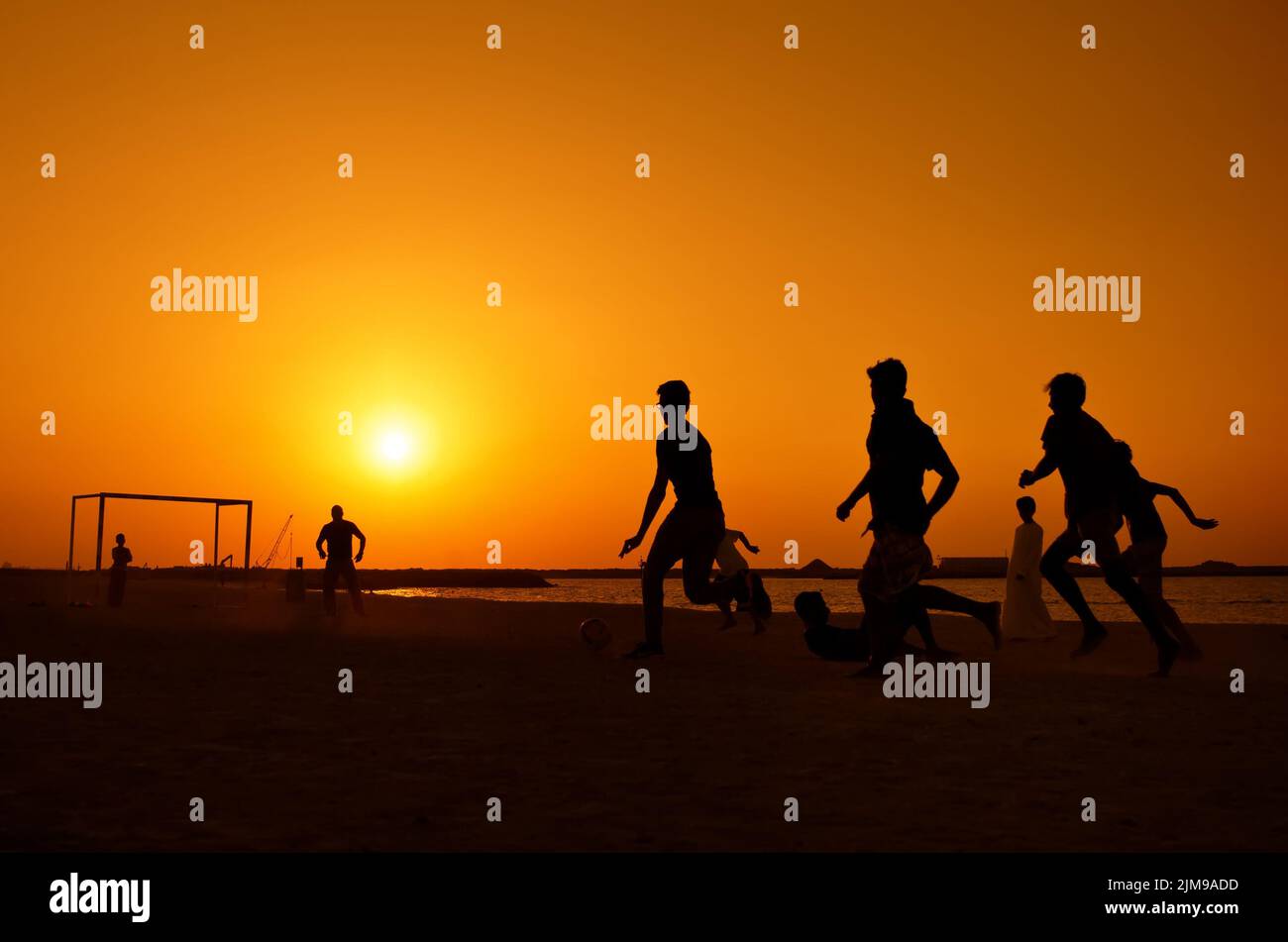 Amateuren, die am Jumeira Beach in Dubai Fußball spielen Stockfoto