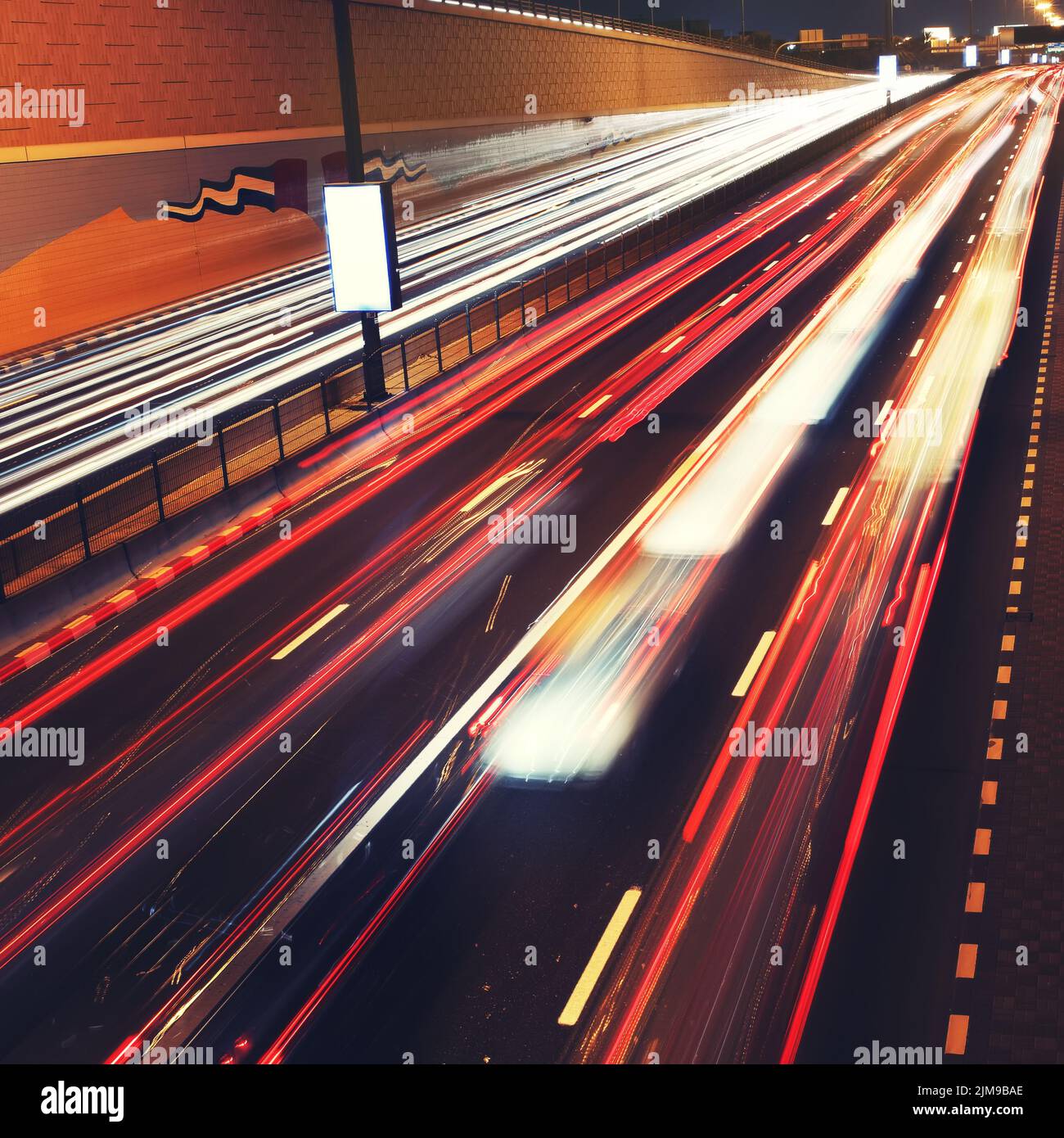 Auf der Straße von Dubai verwischen sich die Verkehrsampeln in Bewegung. Stockfoto