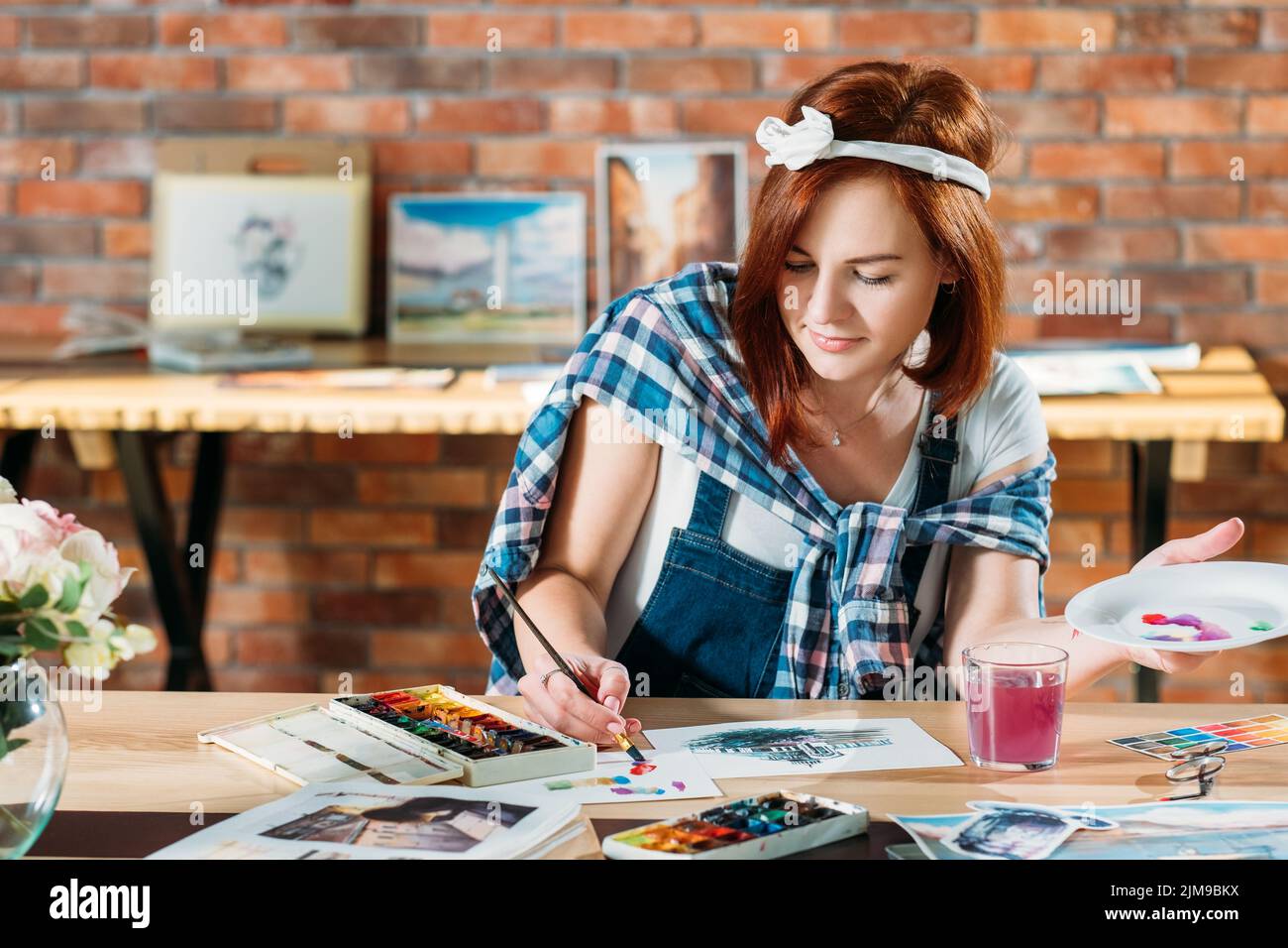 Rotschopf weibliche Künstlerin Arbeit Aquarell Malerei Stockfoto