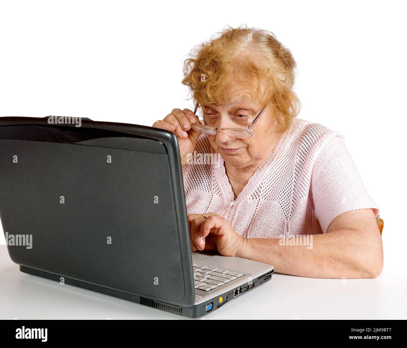 Die alte Frau schaut auf das Bildschirmnotizbuch Stockfoto