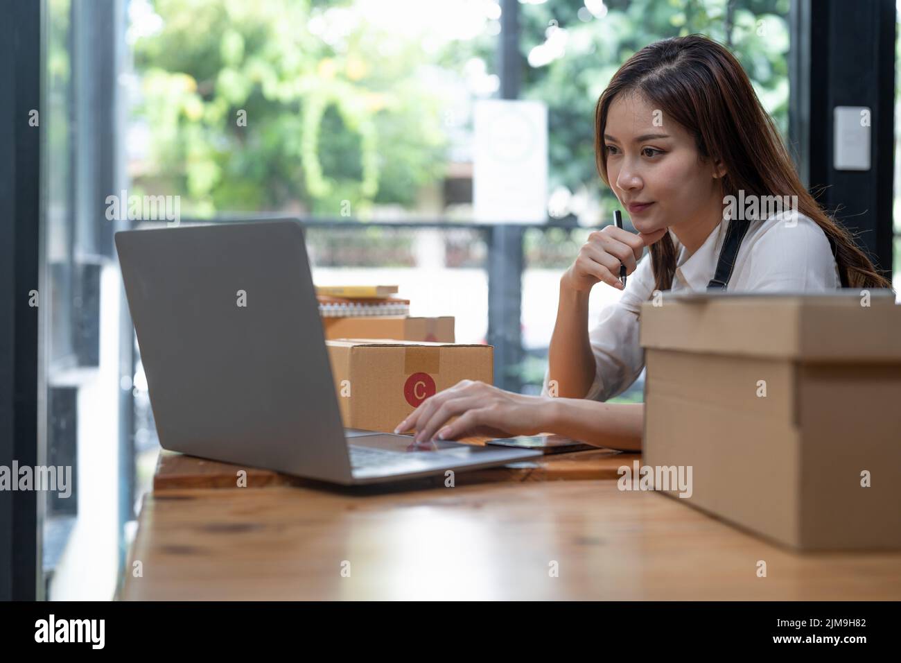 Selbstbewussten jungen Geschäftsfrau an Online Business Store funktioniert. Inhaber kleiner Unternehmen an ihrem Schreibtisch. Stockfoto