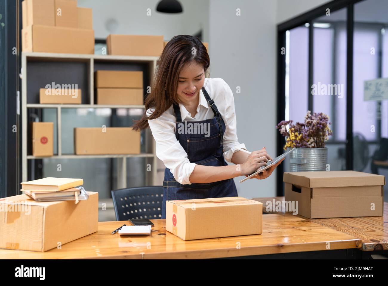 Selbstbewussten jungen Geschäftsfrau an Online Business Store funktioniert. Inhaber kleiner Unternehmen an ihrem Schreibtisch. Stockfoto
