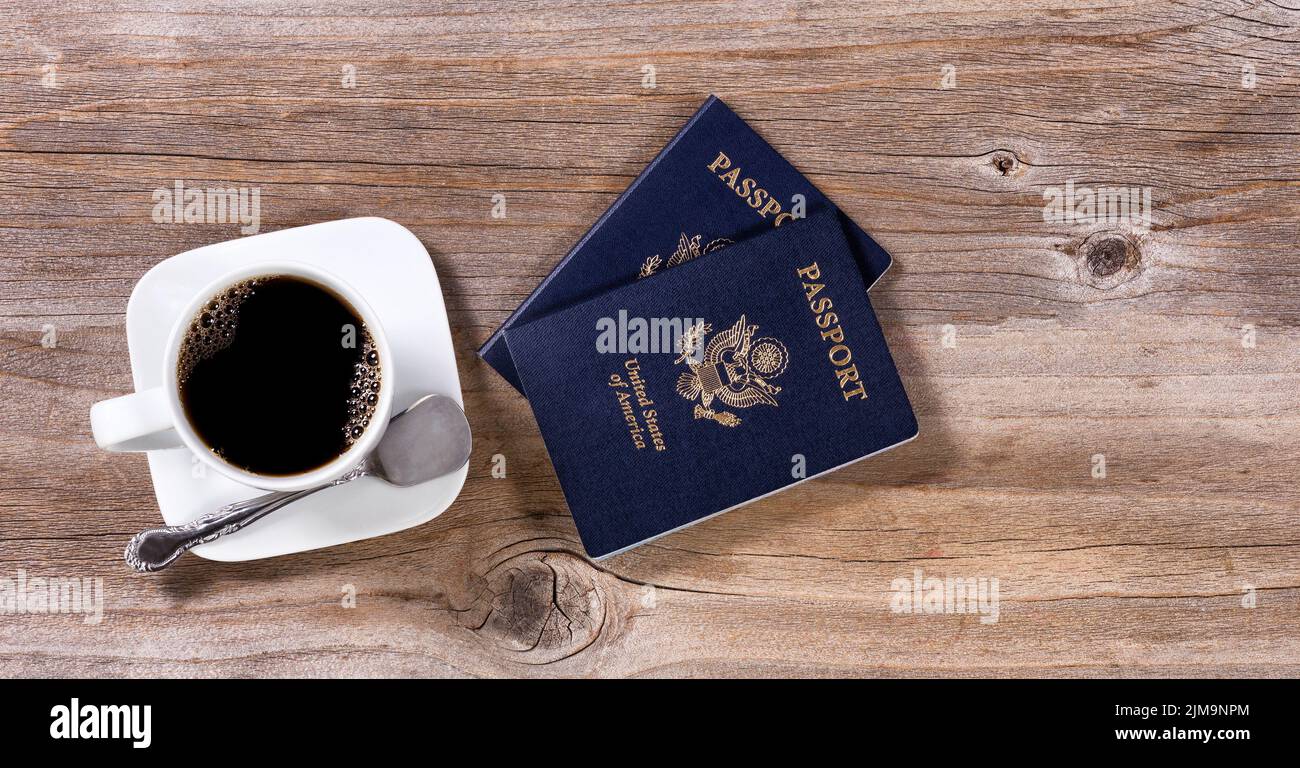 Planung von Reisen mit Pässen und dunklem Kaffee auf rustikalem Holzbrett Stockfoto
