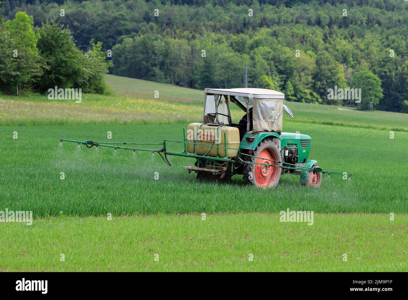 Alter Traktor mit Feldspritze. Stockfoto