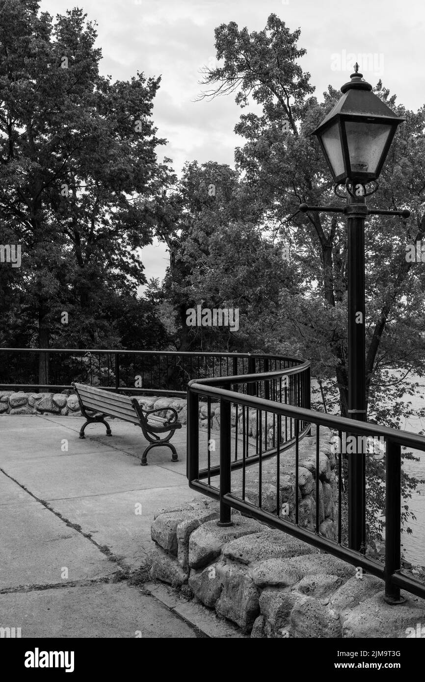 Lamppost und Bank in Schwarz und Weiß mit Blick auf den St. Croix River bei Taylors Falls, Minnesota, USA. Stockfoto