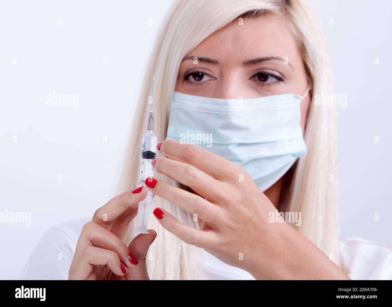 Ärztin oder Krankenschwester in medizinischer Maske mit Spritze mit Injektion, Corona-Virus-Impfstoff Stockfoto