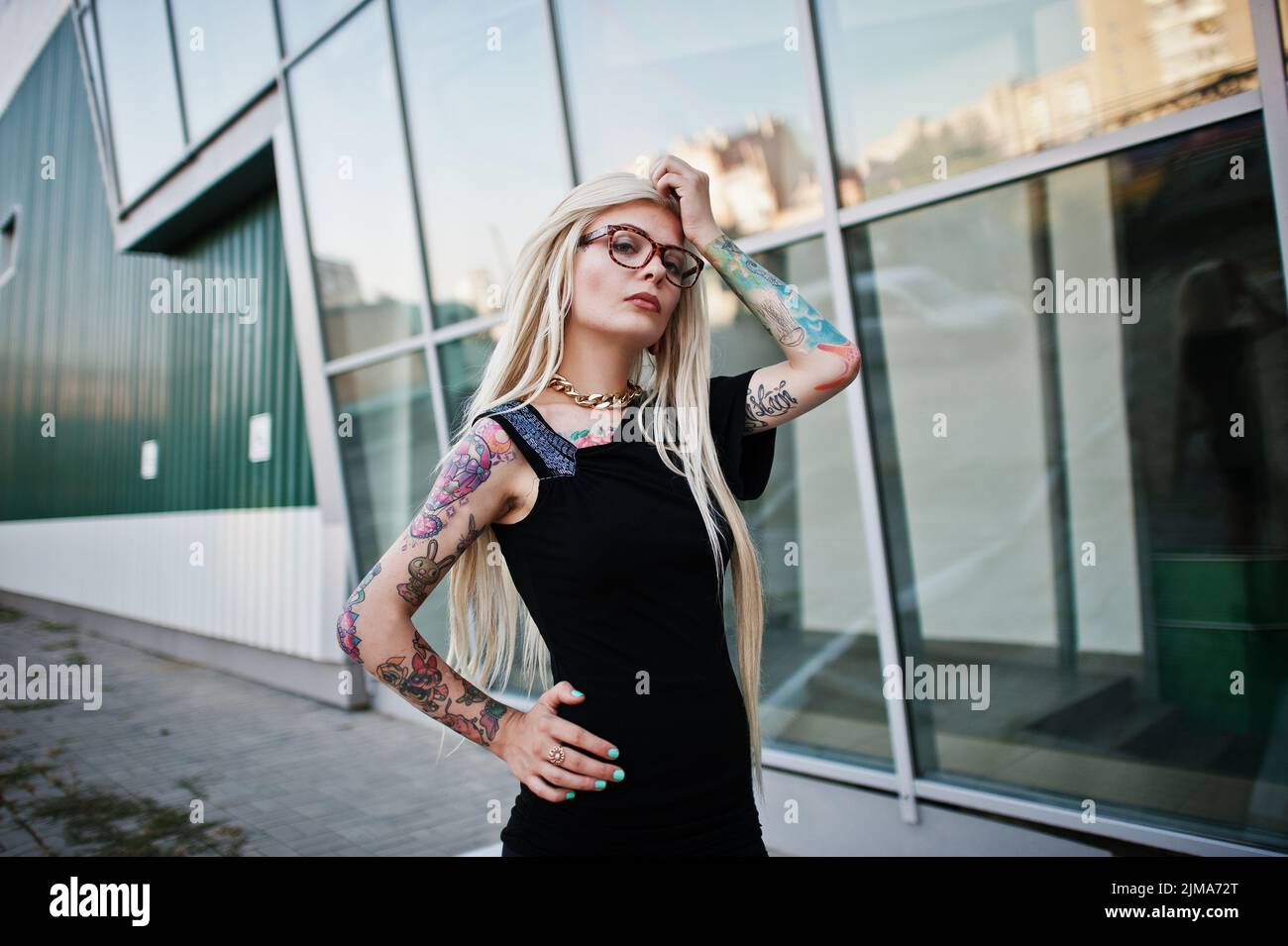 Junge blonde Tattoo Mädchen Hintergrund Hightech-Windows-Architektur Stockfoto