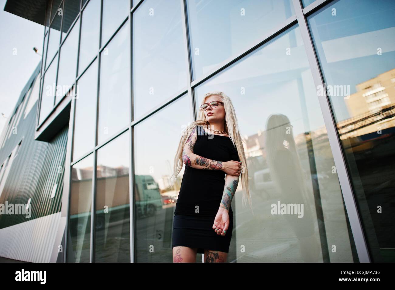 Junge blonde Tattoo Mädchen Hintergrund Hightech-Windows-Architektur Stockfoto