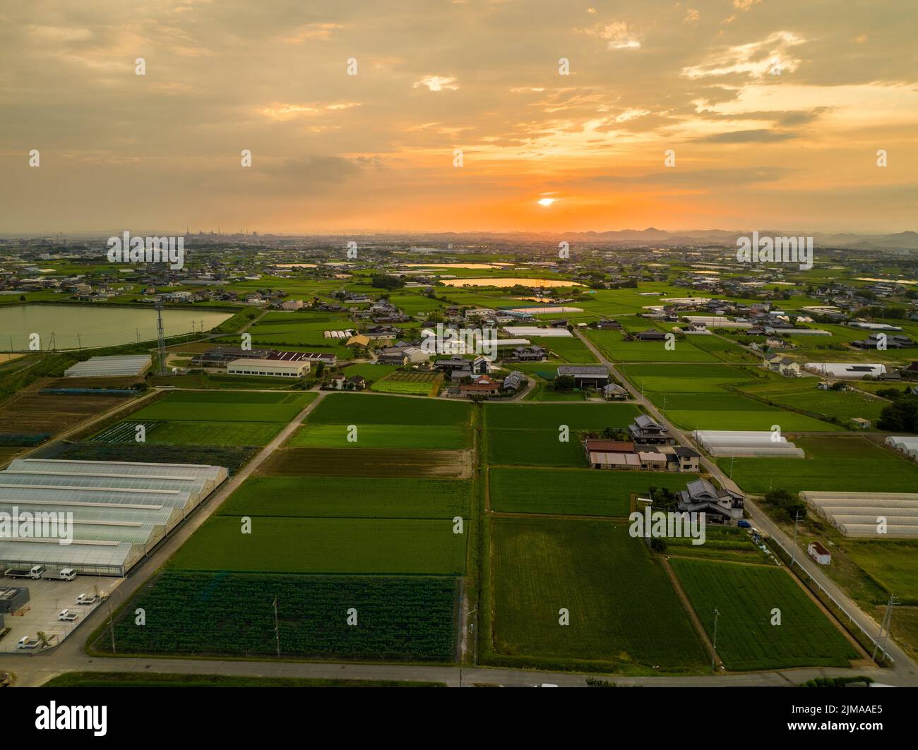 Die Sonne geht über Landstraßen und Reisfeldern im ländlichen Japan unter Stockfoto