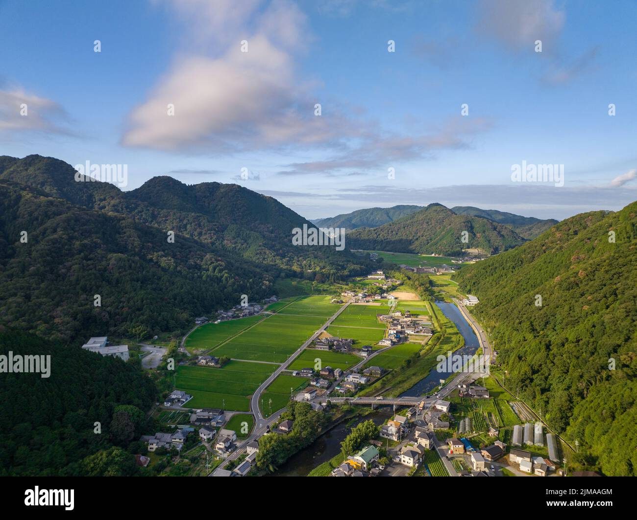 Die Morgensonne trifft auf Reisfelder und kleine Bauerngemeinschaften entlang des Flusses im Tal Stockfoto