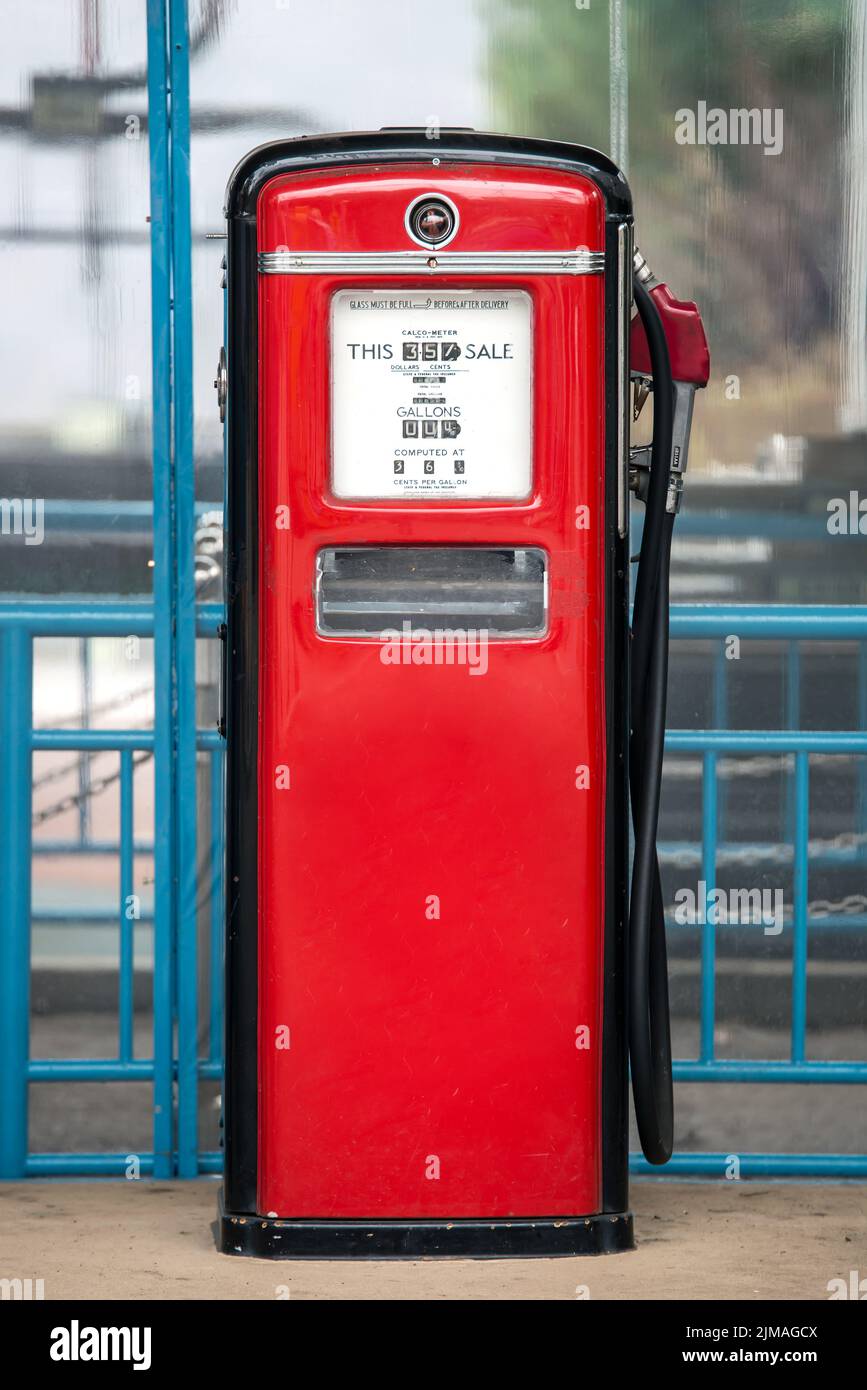 Uralte Gasförderpumpe lackiert in schwarz und rot in der Umgebung von einer alten Tankstelle Stockfoto