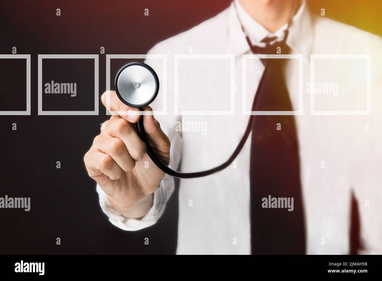 Junger Arzt und Checkbox, Doktor mit einem Stethoskop in den Händen auf schwarzem Hintergrund Stockfoto
