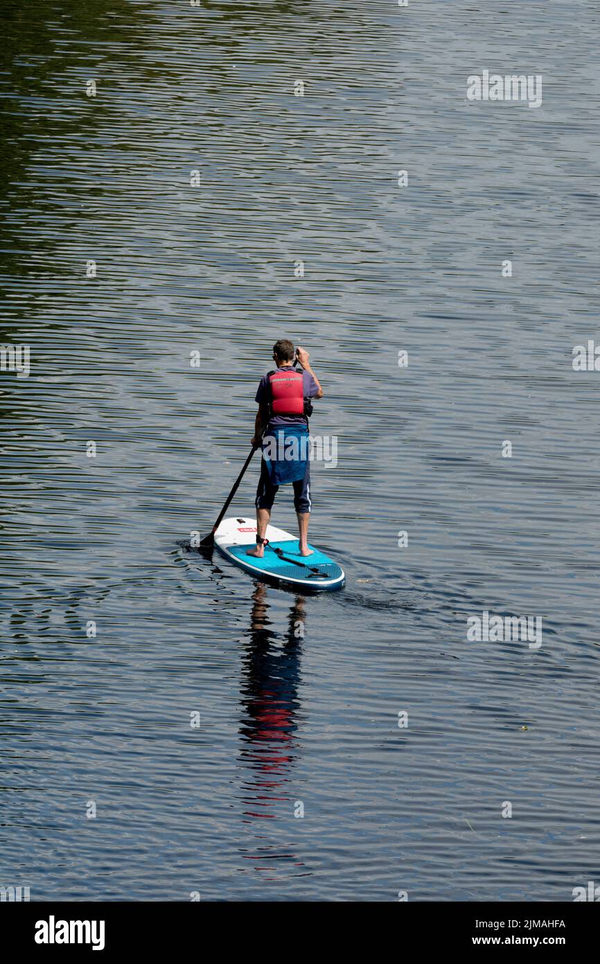 Ein Mann, der auf dem Fluss Avon, Warwick, Warwickshire, Großbritannien paddelt Stockfoto