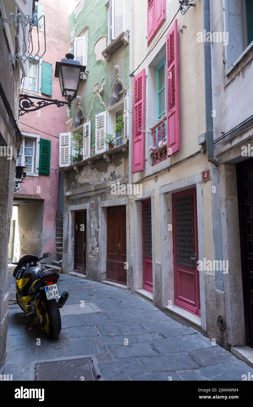 Geparktes Motorrad in einer engen malerischen Straße im historischen Zentrum von Piran. Slowenien. Stockfoto