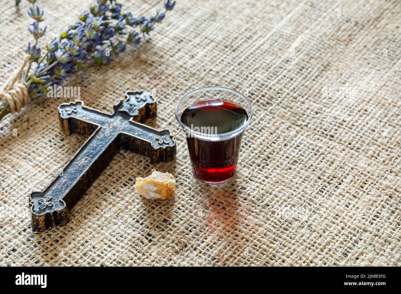Kommunion mit einem Glas Wein und Brot in der Nähe von Cross und lavanda Stockfoto
