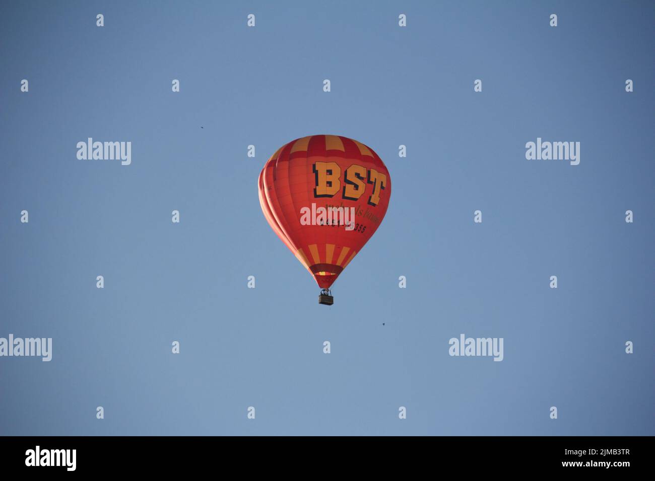 Ein BST-Heißluftballon, der hoch am blauen Himmel über dem Zentrum von Hambourg fliegt Stockfoto