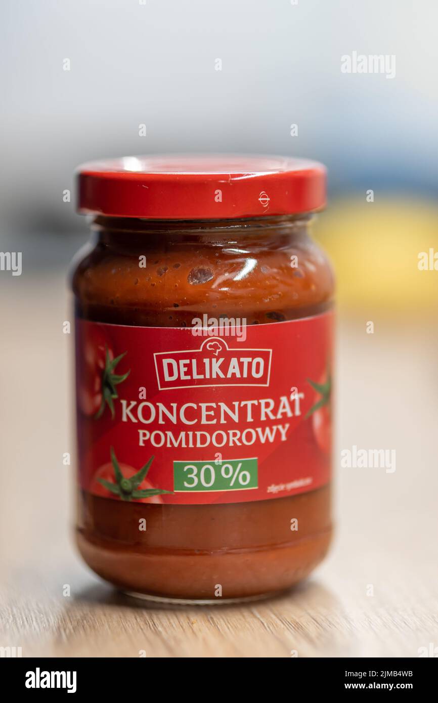 Das Tomatenpüree der Marke Delikato in einem kleinen Glasgefäß, das auf einer Holzoberfläche steht. Stockfoto