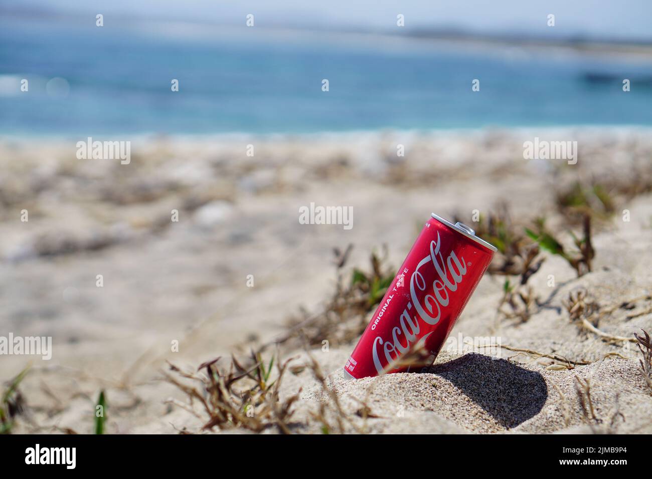 Dompu, Indonesien - 17. August 2018: Closeup Coca Cola Dose am Strand Sand Stockfoto