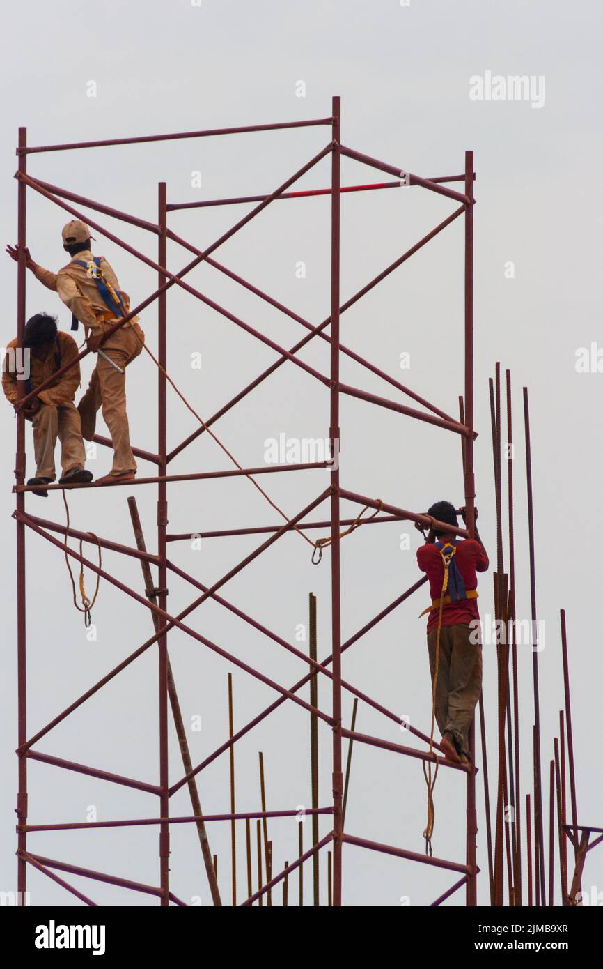 Bauarbeiter auf Gerüsten auf einer Baustelle in Chennai, die minimale Sicherheitsvorkehrungen treffen. Stockfoto