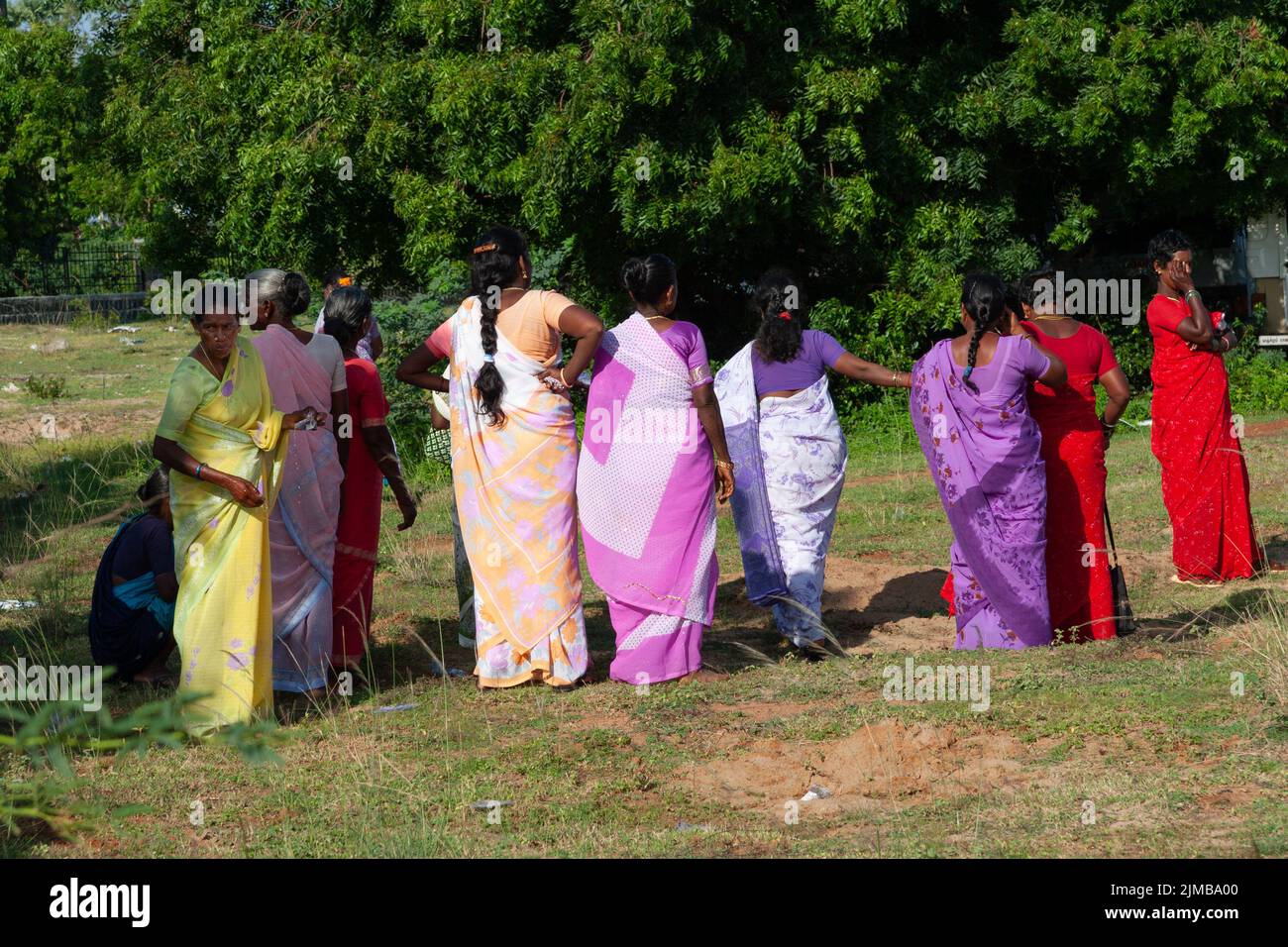 Indische Frauen in farbenfrohen traditionellen fsari gekleidet und bereiten sich auf eine Open-Air-Feier in Mahabalipuram vor. Stockfoto