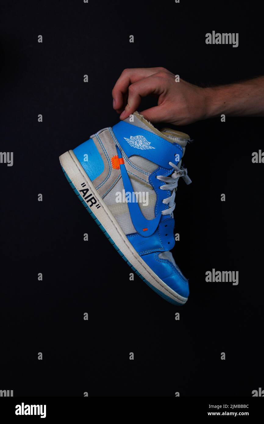 Eine vertikale Aufnahme eines blauen Air Jordan 1 Sneakers vor dunklem Hintergrund Stockfoto