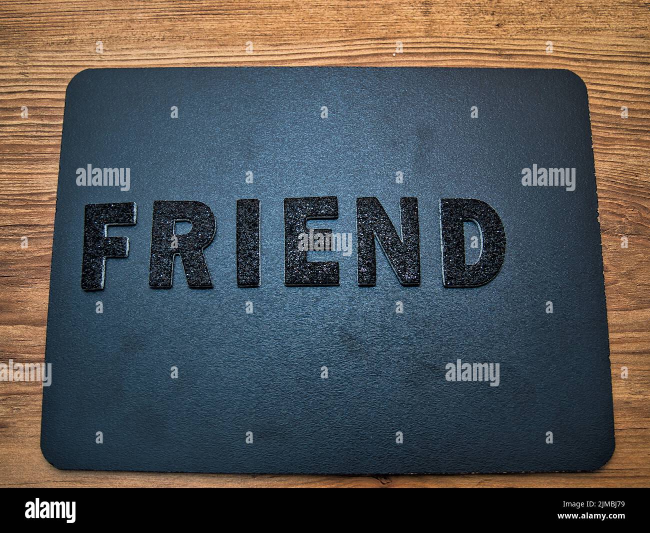 Das Wort Friend in schwarzen Buchstaben auf schwarzem Hintergrund. Perfekt, um dir auf einem Social-Media-Beitrag zu zeigen, was dir wichtig ist. Stockfoto