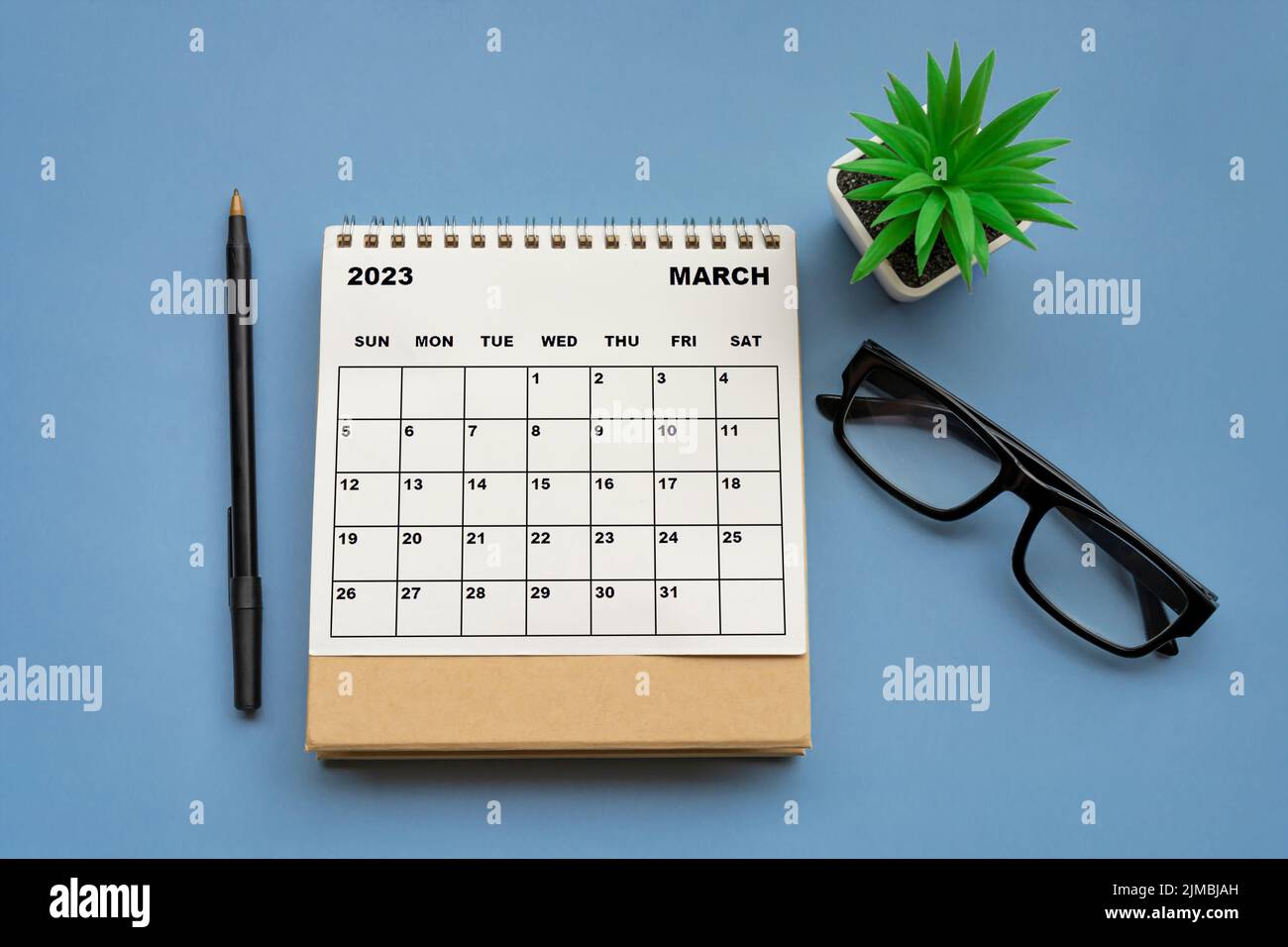 Schreibtisch-Kalender März 2023 auf blauem Hintergrund. Direkt darüber. Stockfoto