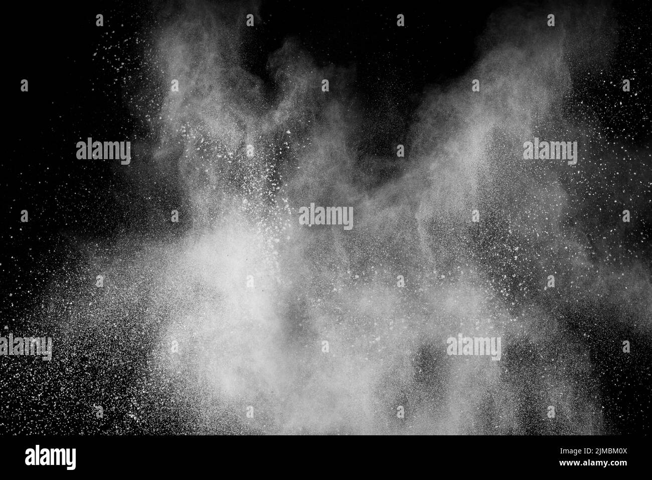 Bizarre Formen der weißen Pulverexplosions-Wolke vor schwarzem Hintergrund. Stockfoto