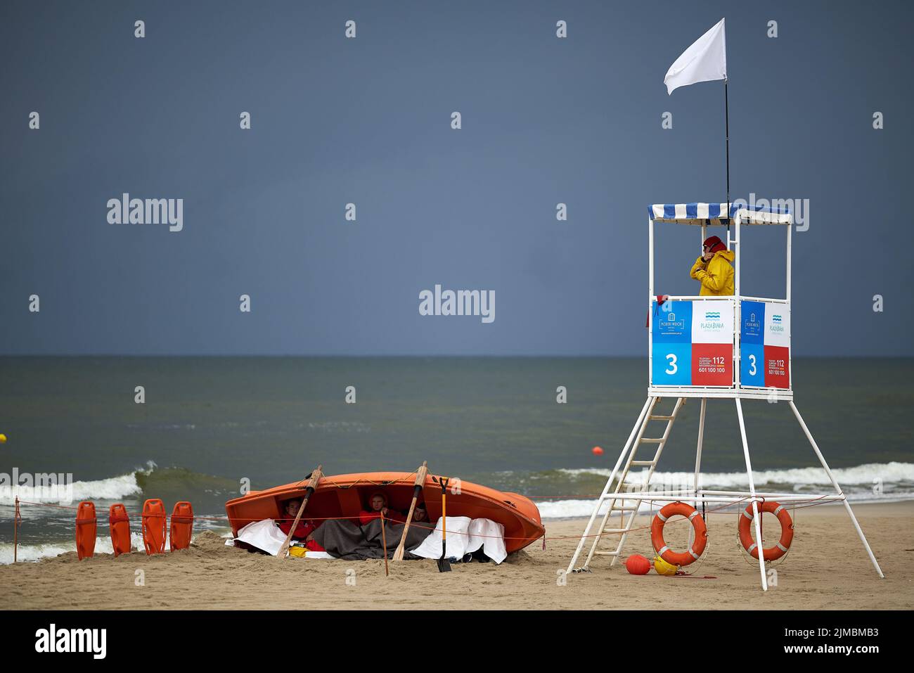 Rettungsschwimmer verstecken sich während eines Sturms am Strand im Rettungsboot Stockfoto