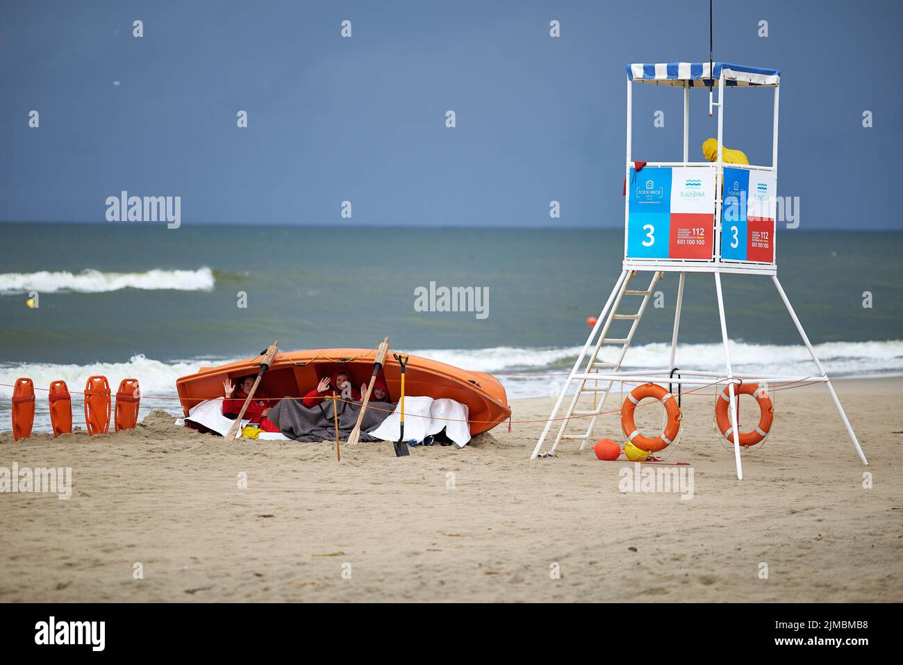 Rettungsschwimmer verstecken sich während eines Sturms am Strand im Rettungsboot Stockfoto