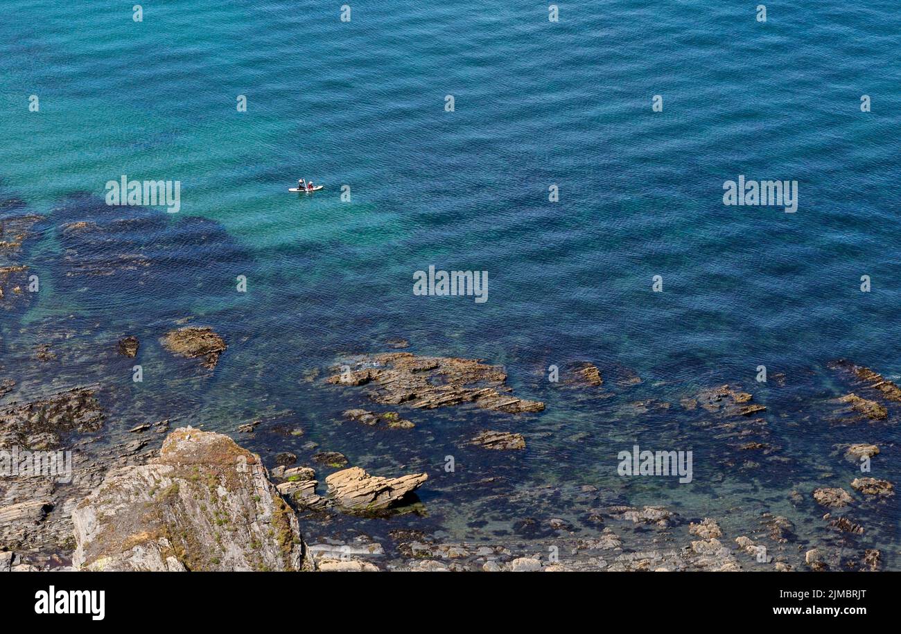 Ein Paar paddelt an einer malerischen Felsküste. Gesundheit, Fitness, Urlaub, Urlaub, Erlebniskonzept. Stockfoto