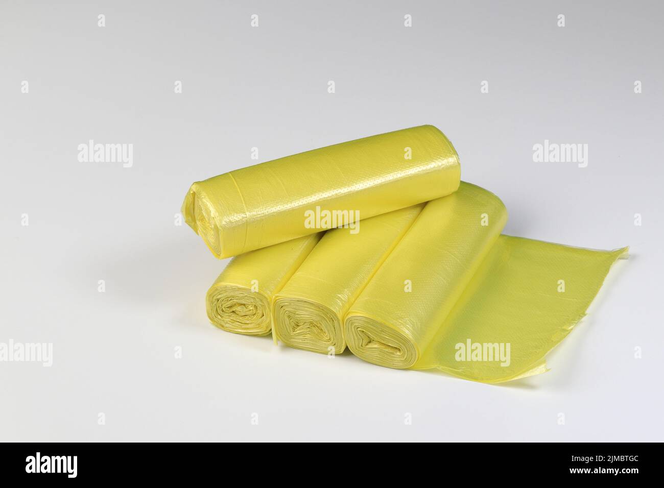 Gelbe Müllsäcke Rollen, Rolle von Plastikmülltüten isoliert auf weißem Hintergrund Stockfoto