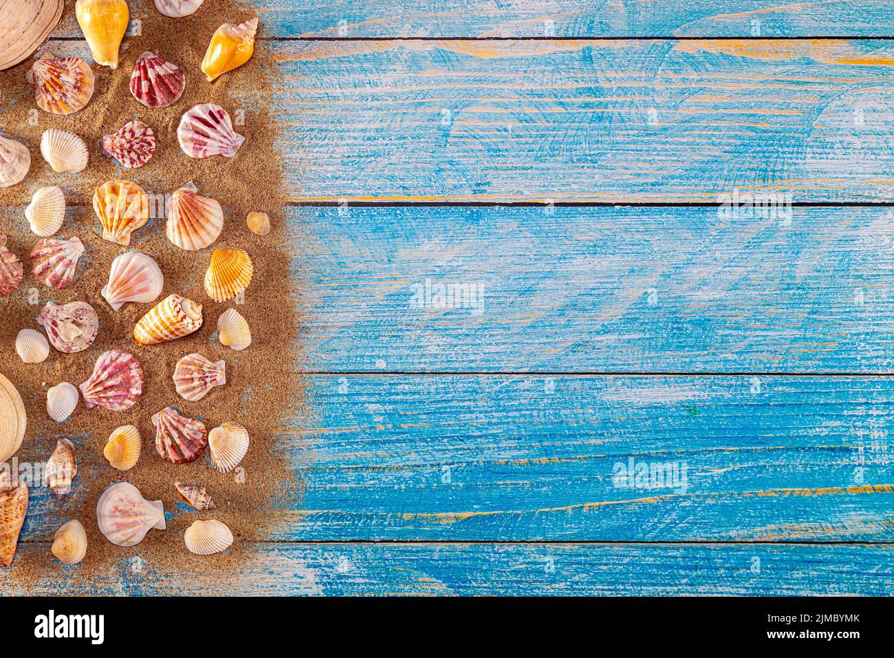 Sommerzeitkonzept mit Muscheln auf blauem Holzhintergrund und Sand Stockfoto Sommerzeitkonzept mit Muscheln auf blauem Holzhintergrund und Sand Stockfoto