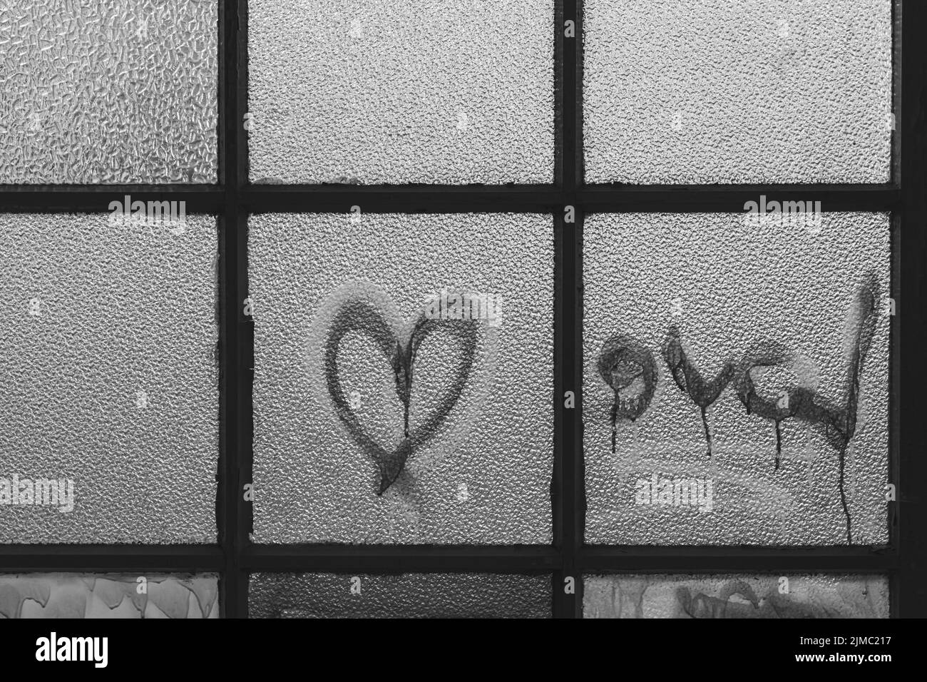 Ein altes Fenster mit Glasscheibe und dem Schriftzug Love Stockfoto